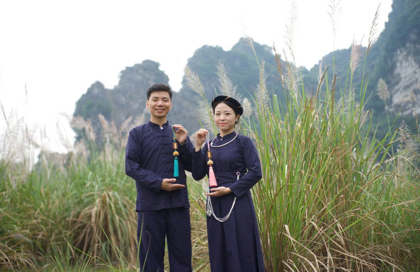 Hai người mặc trang phục chàm trước núi